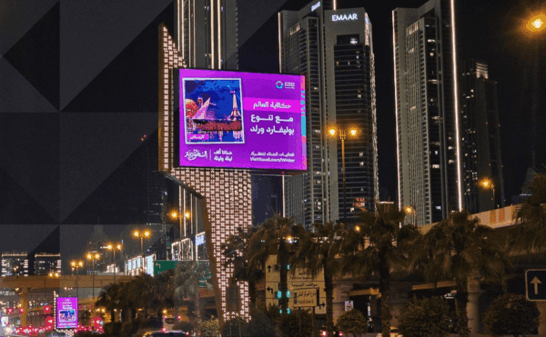 Abu Dhabi DOOH Advertising displayed on a roadside digital screen in a high-traffic urban night setting
