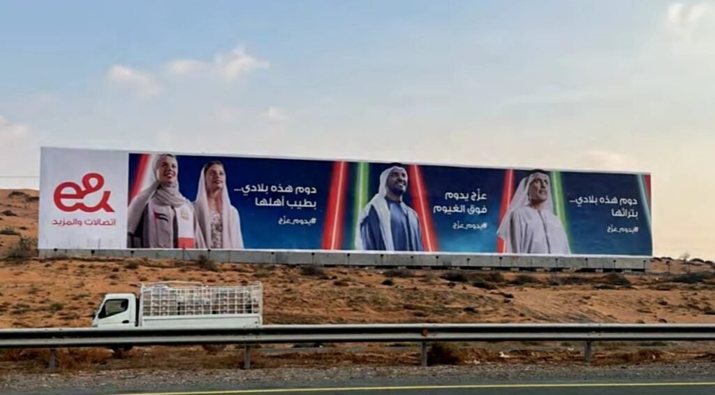 Large-format billboard on a busy highway showcasing Outdoor Media in RAK with high-impact visibility for daily commuters