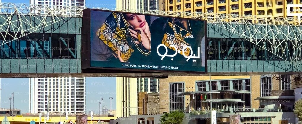 High-impact LED outdoor billboard installed near shopping mall facade in dense urban commercial area