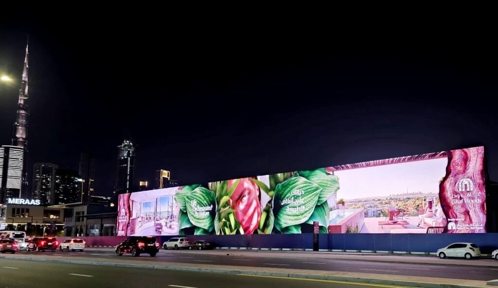 DOOH campaign planning showcased through a large-format LED billboard along a busy Dubai roadway at night