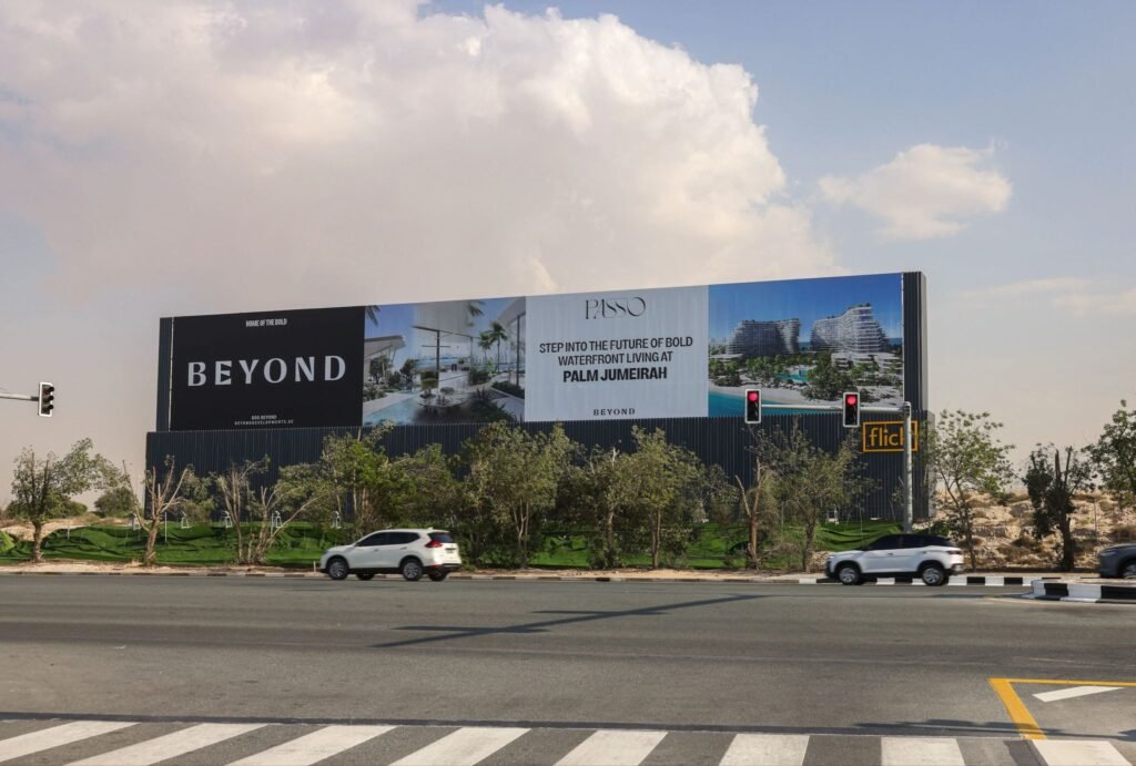 Real estate waterfront development billboard at a traffic signal junction, leveraging High-Impact Advertising Formats for long dwell-time visibility.