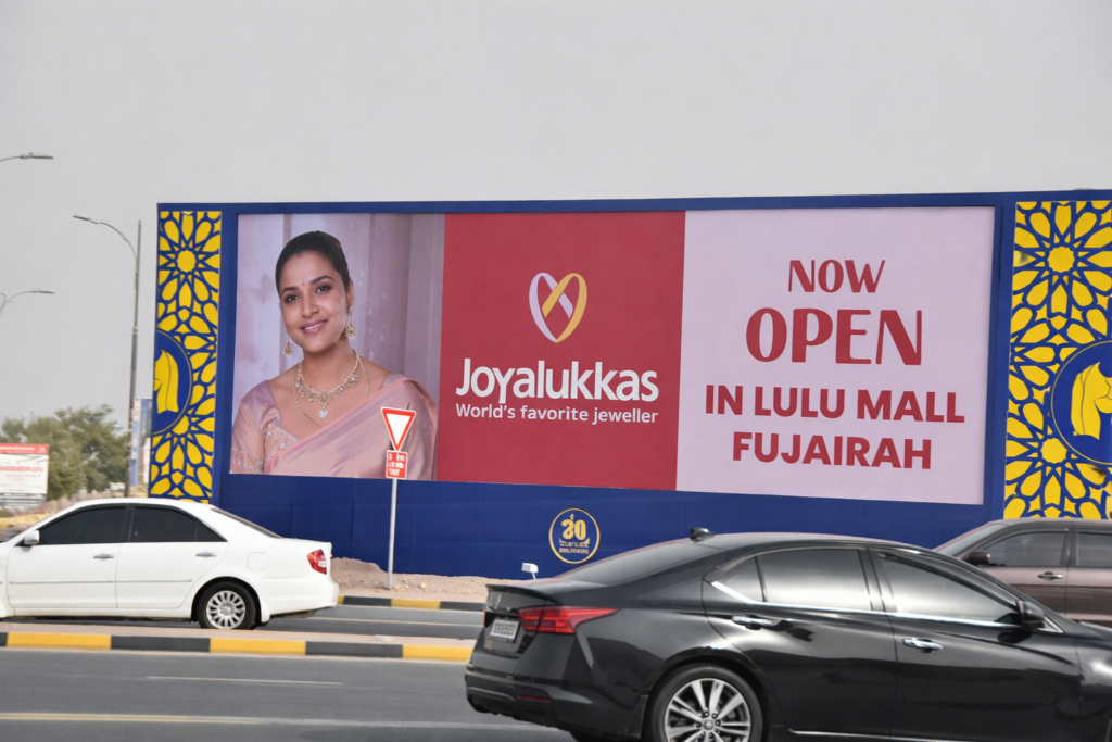 Multiple lamp post advertising panels aligned along roadside promoting retail discount campaign for DOOH Advertising Fujairah